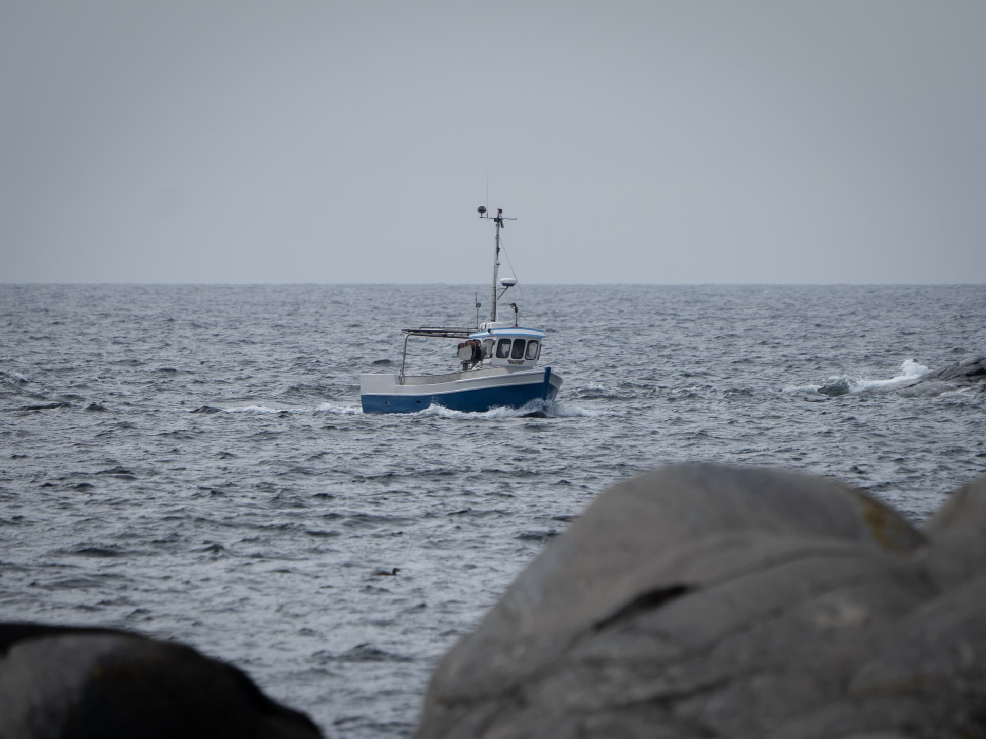 A small fishing boat heading out through open Swedish coastal waters